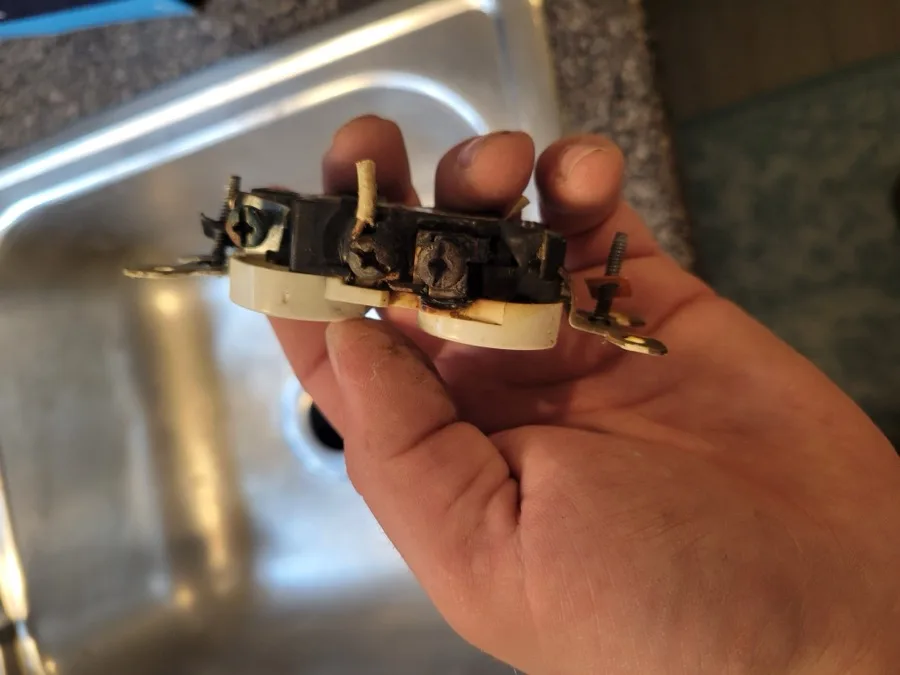 A corroded, overheated electrical outlet removed during a service call
